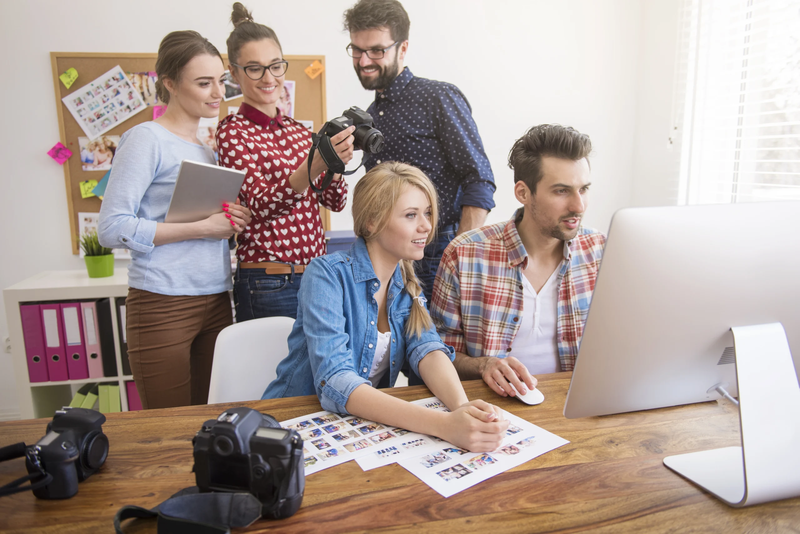 Creative team collaborating on digital content and photo editing project in office